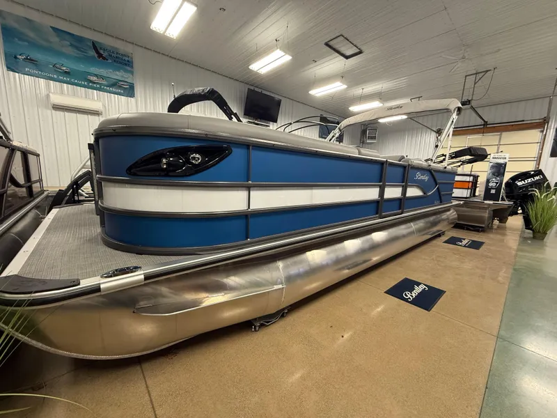 Slide: The Image of 2025 Bentley Pontoons Legacy 240 Cruise in showroom, blue and silver design. - 2
