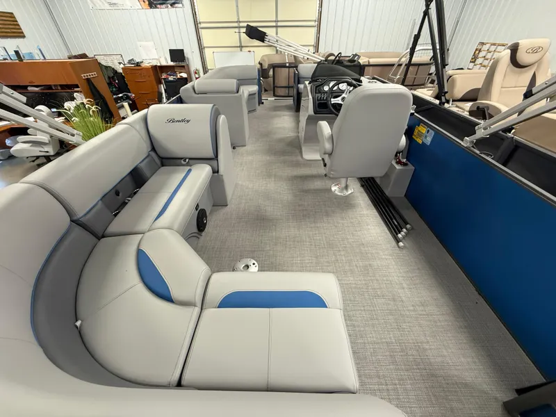 Slide: The Image of 2025 Bentley Pontoons Legacy 240 Cruise interior with gray and blue seating, spacious layout. - 20