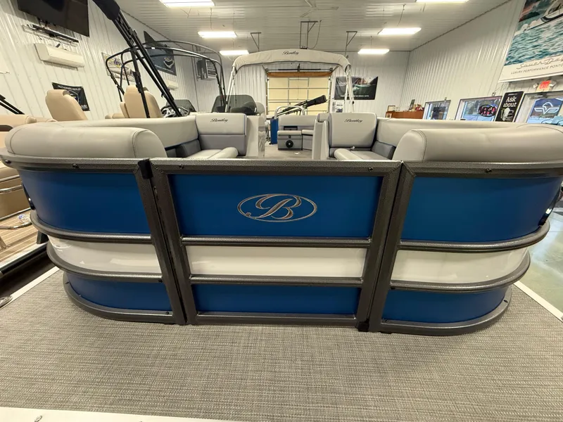 Slide: The Image of 2025 Bentley Pontoons Legacy 240 Cruise, blue and white interior, displayed in a showroom. - 3