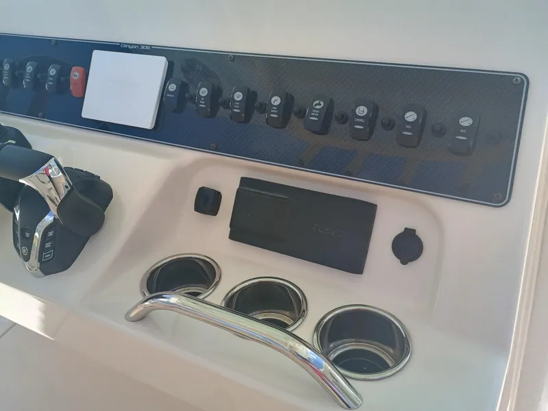 Slide: The Image of Control panel of 2025 Grady-White Canyon 306 boat with switches and throttle. - 10