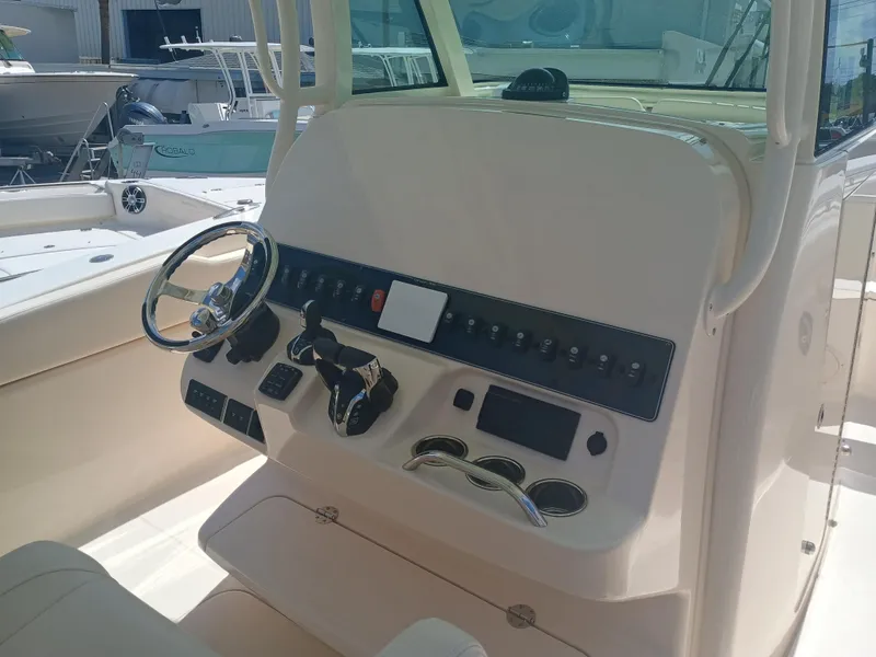 Slide: The Image of 2025 Grady-White Canyon 306 boat dashboard with steering wheel and controls. - 11