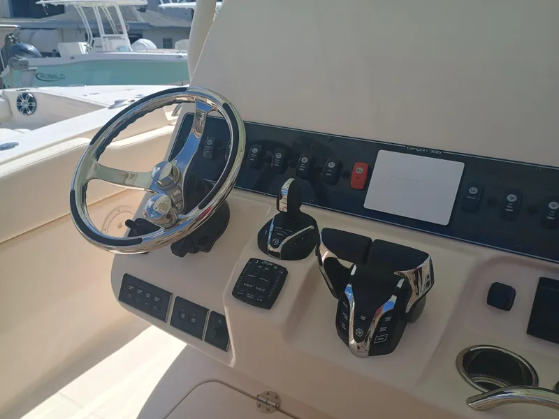 Slide: The Image of 2025 Grady-White Canyon 306 boat dashboard with steering wheel and controls. - 12