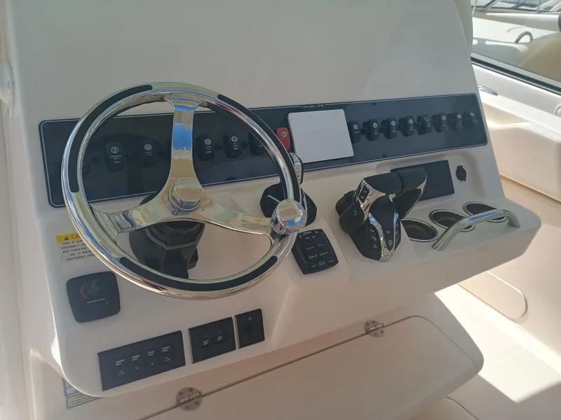 Slide: The Image of Control panel of 2025 Grady-White Canyon 306 boat with steering wheel and controls. - 13