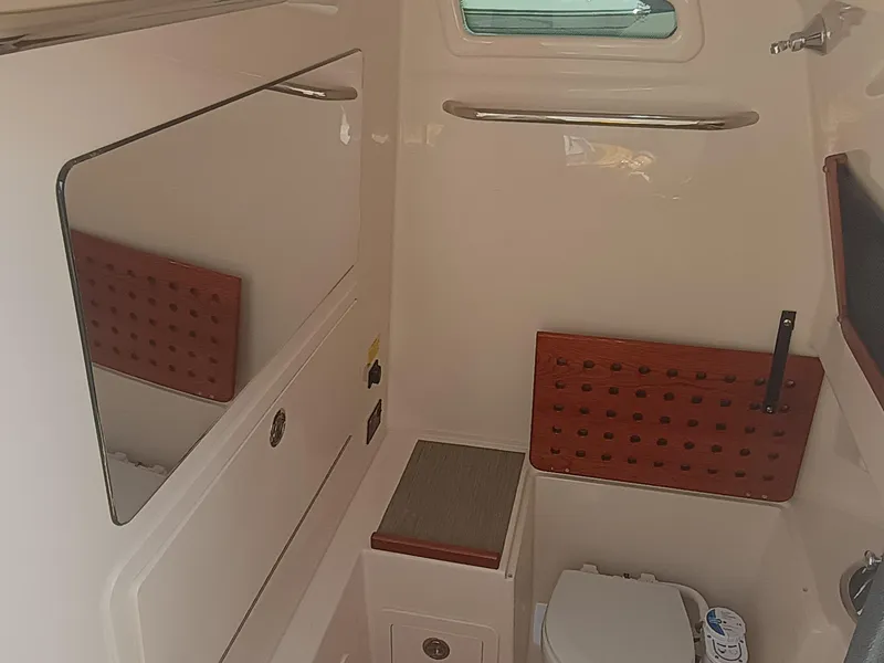 Slide: The Image of 2025 Grady-White Canyon 306 boat interior with mirror, window, and toilet. - 20