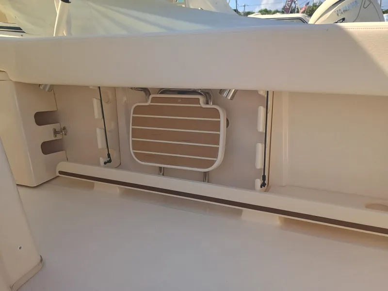 Slide: The Image of 2025 Grady-White Canyon 306 boat interior detail, showcasing storage compartment and seating area. - 23