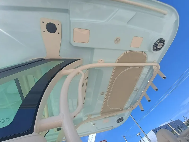 Slide: The Image of 2025 Grady-White Canyon 306 boat roof with speakers and rod holders under clear blue sky. - 8