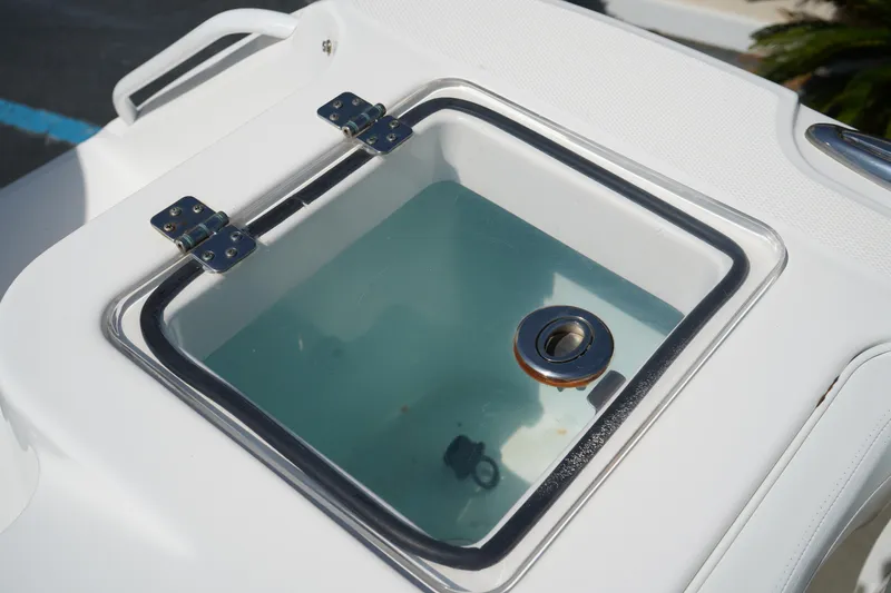 Slide: The Image of Livewell on 2018 Edgewater 262 CX boat, featuring a clear lid and secure hinges. - 13