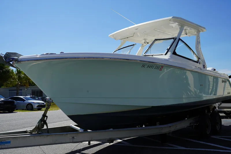 Slide: The Image of 2018 Edgewater 262 CX boat on trailer, parked outdoors under clear sky. - 2