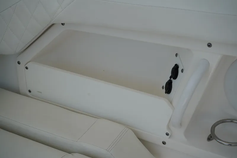 Slide: The Image of Storage compartment on 2018 Edgewater 262 CX boat, featuring white interior and cup holder. - 23