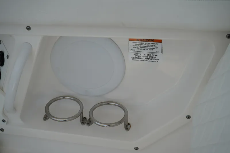 Slide: The Image of 2018 Edgewater 262 CX boat interior with cup holders and safety label. - 24
