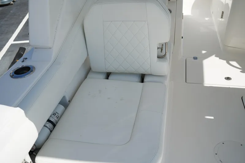 Slide: The Image of Luxurious white seating on 2018 Edgewater 262 CX boat, featuring quilted upholstery. - 25
