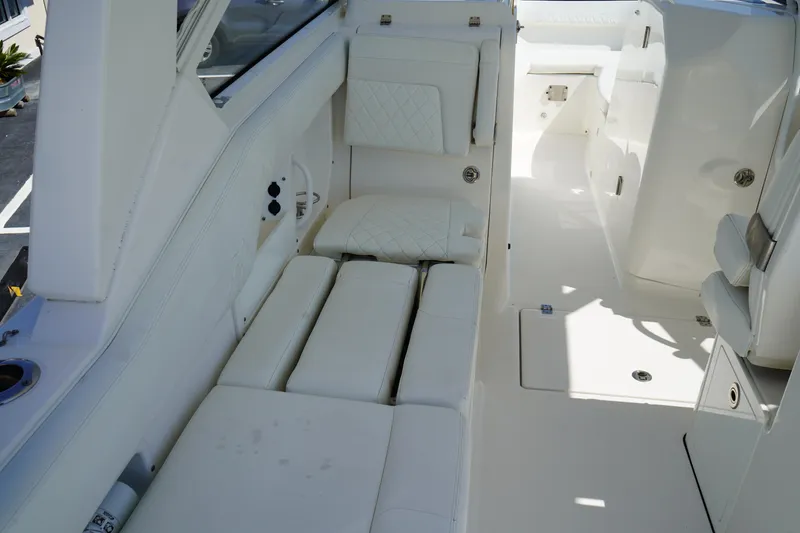 Slide: The Image of 2018 Edgewater 262 CX boat interior with white cushioned seating and sleek design. - 28