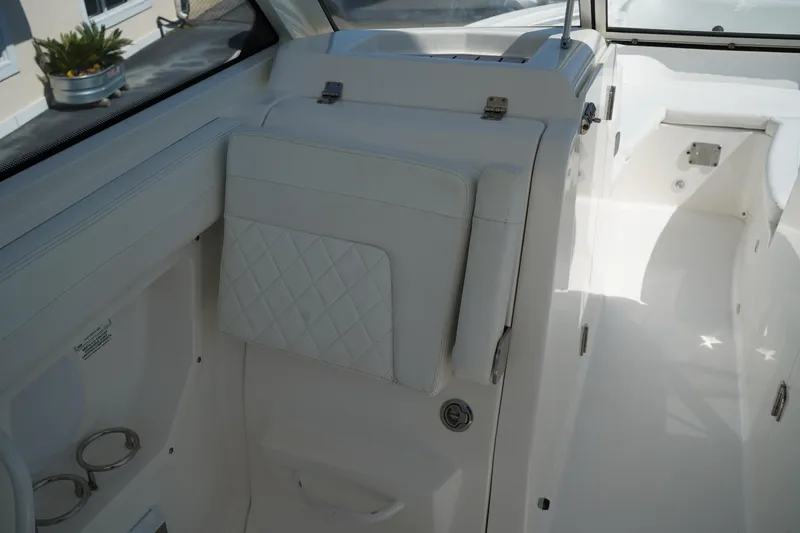 Slide: The Image of 2018 Edgewater 262 CX boat interior with white seating and cup holders. - 29