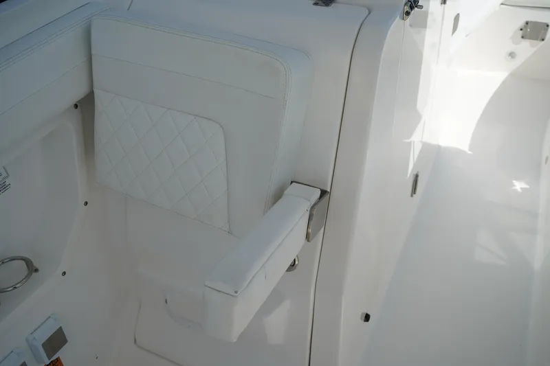 Slide: The Image of 2018 Edgewater 262 CX boat interior with white cushioned seating and armrest. - 30