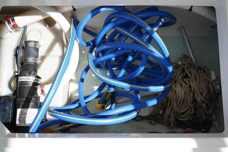 Slide: The Image of Storage compartment of 2018 Edgewater 262 CX with blue hose and rope. - 33