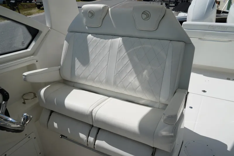 Slide: The Image of Luxurious seating on 2018 Edgewater 262 CX boat, featuring white leather upholstery and armrests. - 34