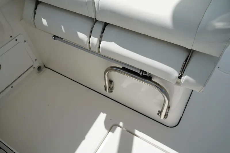Slide: The Image of White seating area on 2018 Edgewater 262 CX boat, featuring stainless steel grab handle. - 36