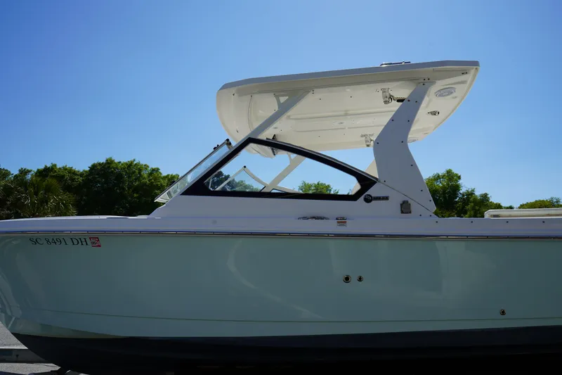 Slide: The Image of 2018 Edgewater 262 CX boat with sleek design against a clear blue sky. - 4