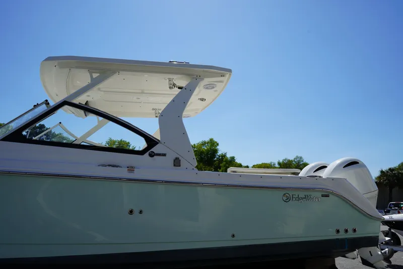 Slide: The Image of 2018 Edgewater 262 CX boat with dual engines under clear blue sky. - 5