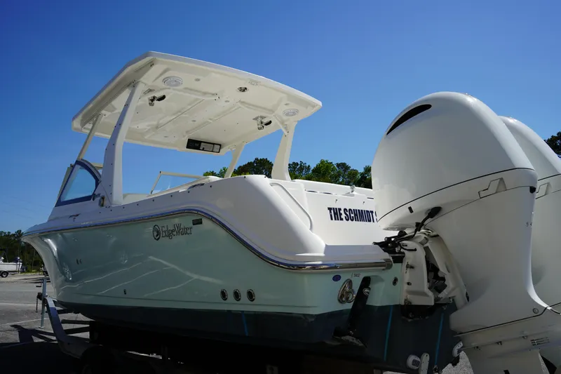 Slide: The Image of 2018 Edgewater 262 CX boat with dual engines, parked under a clear blue sky. - 7