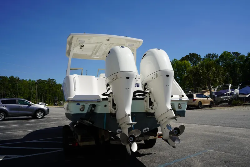 Slide: The Image of 2018 Edgewater 262 CX boat with dual outboard motors in a parking lot. - 8