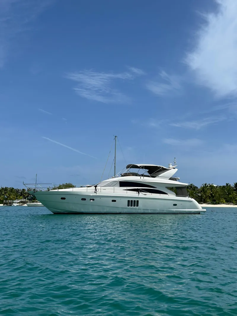 The Image of Luxury 2008 Princess 67 Flybridge yacht on turquoise water, clear sky background. - 0