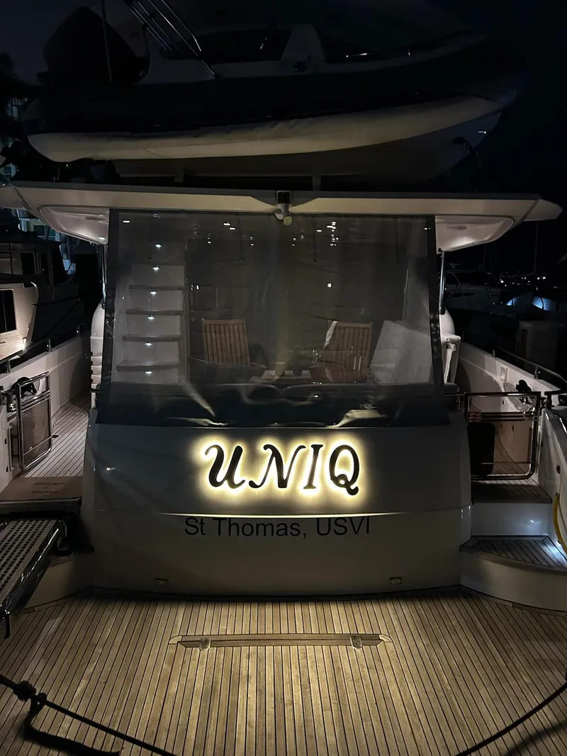 Slide: The Image of 2008 Princess 67 Flybridge yacht docked at night, illuminated name "UNIQ," St. Thomas, USVI. - 6