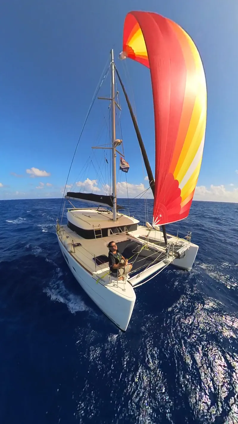 Slide: The Image of 2012 Lagoon 400 catamaran sailing with vibrant spinnaker on open ocean. - 2