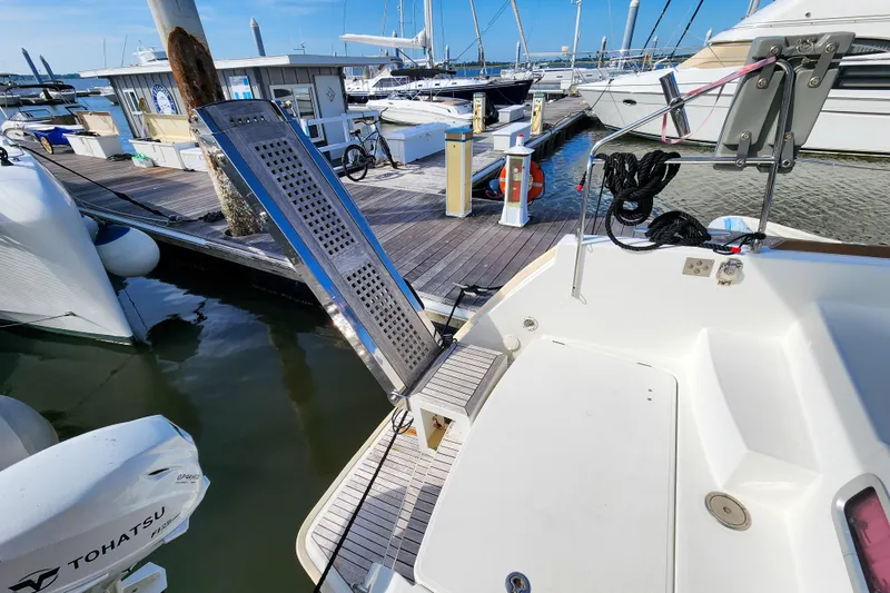 Slide: The Image of Lagoon 400 catamaran docked at marina, featuring a boarding ramp and Tohatsu outboard motor. - 27