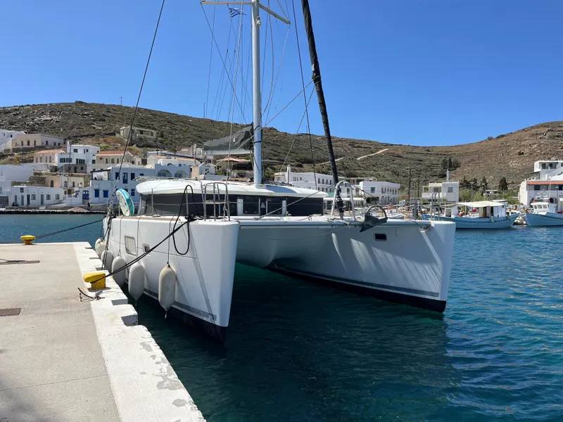 Slide: The Image of 2012 Lagoon 400 catamaran docked in a scenic harbor with hillside buildings. - 3