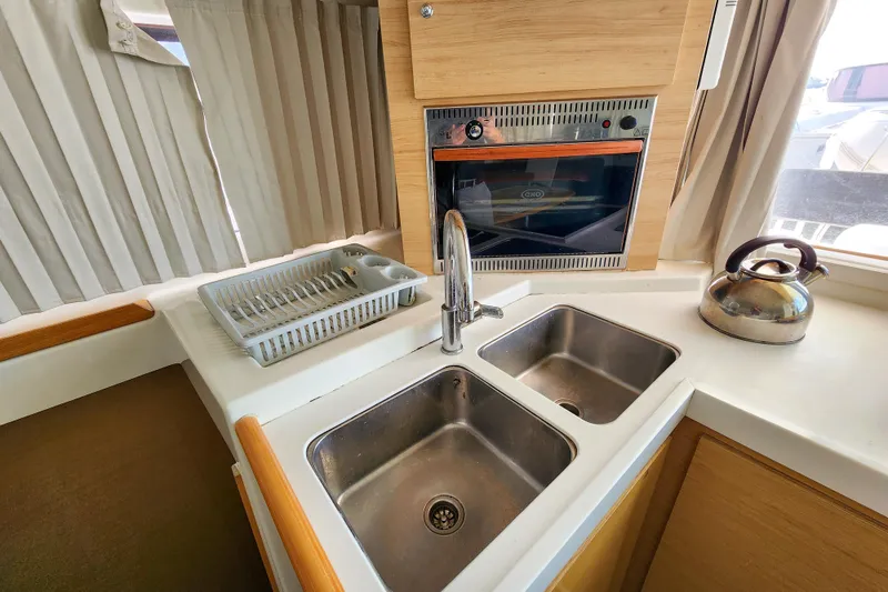 Slide: The Image of Compact kitchen area in a 2012 Lagoon 400 yacht with sink, oven, and kettle. - 35