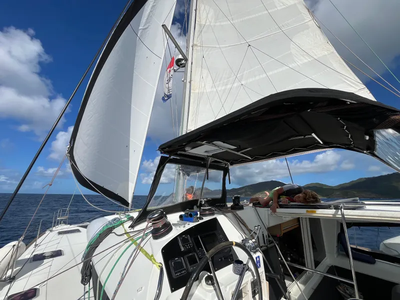 Slide: The Image of Sailing on a 2012 Lagoon 400 catamaran with open sails under a clear blue sky. - 49