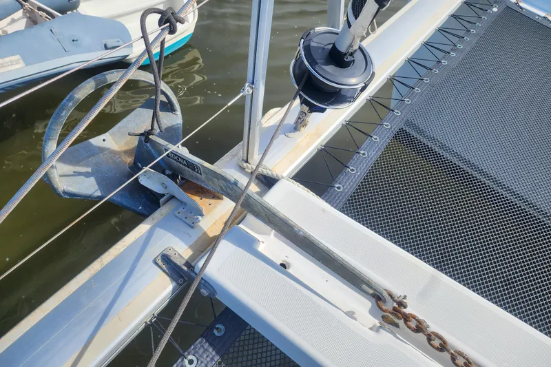 Slide: The Image of Catamaran Lagoon 400 (2012) anchor and netting detail, docked on calm water. - 7