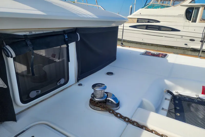 Slide: The Image of 2012 Lagoon 400 yacht deck with winch and chain, docked beside another boat. - 8
