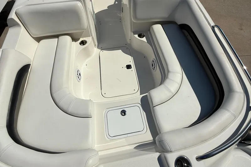 Slide: The Image of 2012 Hurricane SunDeck 217 OB boat interior with white seating and storage compartments. - 10