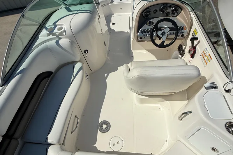 Slide: The Image of 2012 Hurricane SunDeck 217 OB boat interior with white seating and control panel. - 11