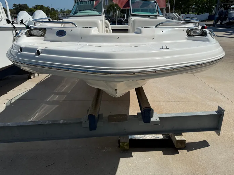Slide: The Image of 2012 Hurricane SunDeck 217 OB boat on trailer, front view, in a marina setting. - 5