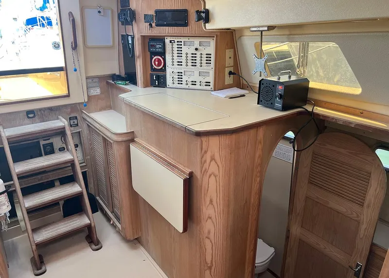 Slide: The Image of Interior of 1998 Island Packet Cat 35 sailboat with wooden cabinetry and navigation equipment. - 10