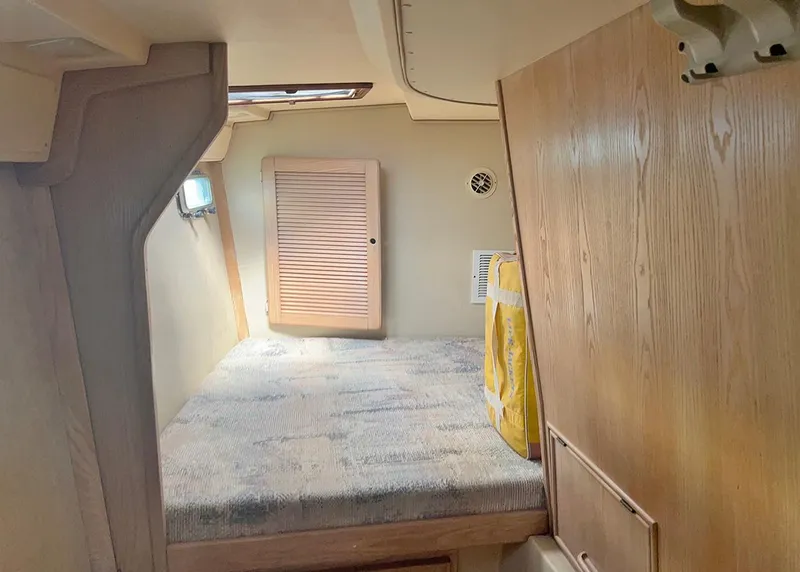 Slide: The Image of 1998 Island Packet Cat 35 cabin interior with bed, wooden paneling, and storage. - 15