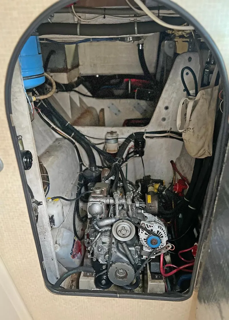 Slide: The Image of Engine compartment of a 1998 Island Packet Cat 35 sailboat, showcasing mechanical components. - 18