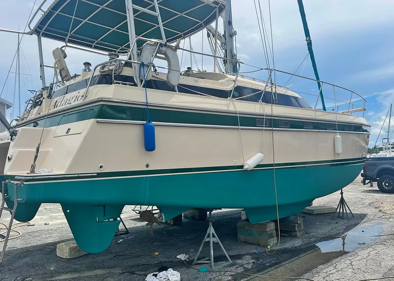 Slide: The Image of 1998 Island Packet Cat 35 sailboat on dry dock, featuring teal and cream hull. - 23