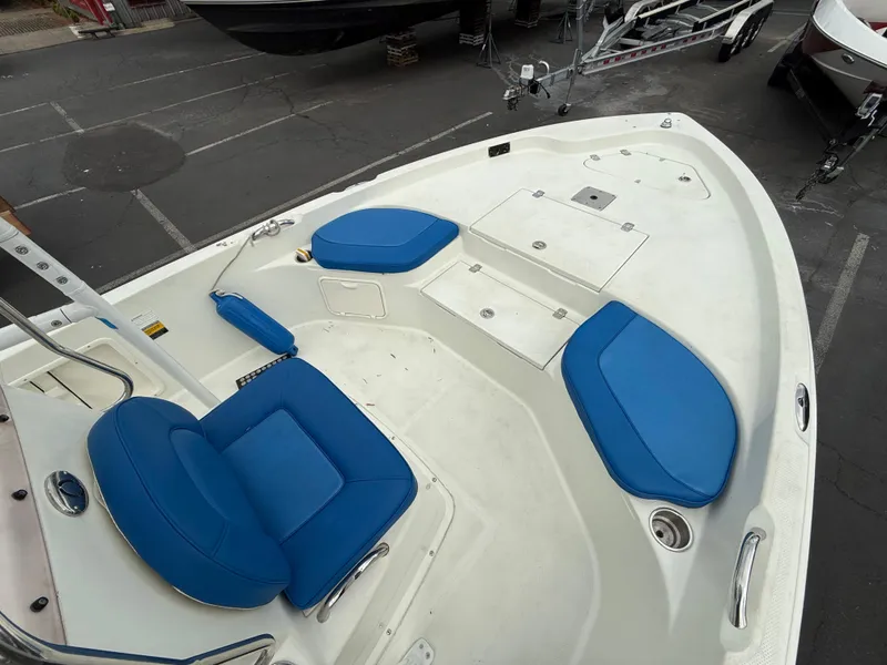 Slide: The Image of 2008 Sailfish 1900 BB Bay Boat with blue seating, docked in a parking area. - 12