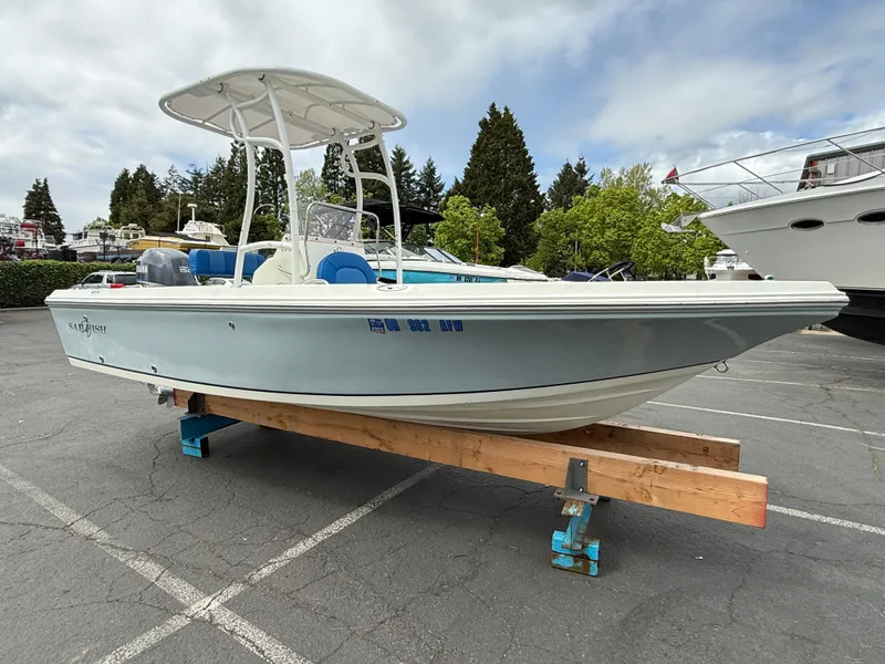 Slide: The Image of 2008 Sailfish 1900 BB Bay Boat on display in a marina parking lot. - 2