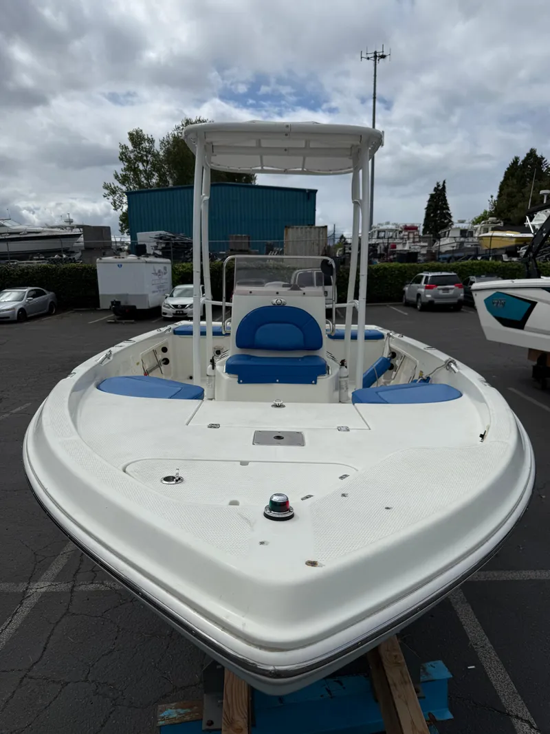 Slide: The Image of 2008 Sailfish 1900 BB Bay Boat with blue seating, docked outdoors under cloudy skies. - 6
