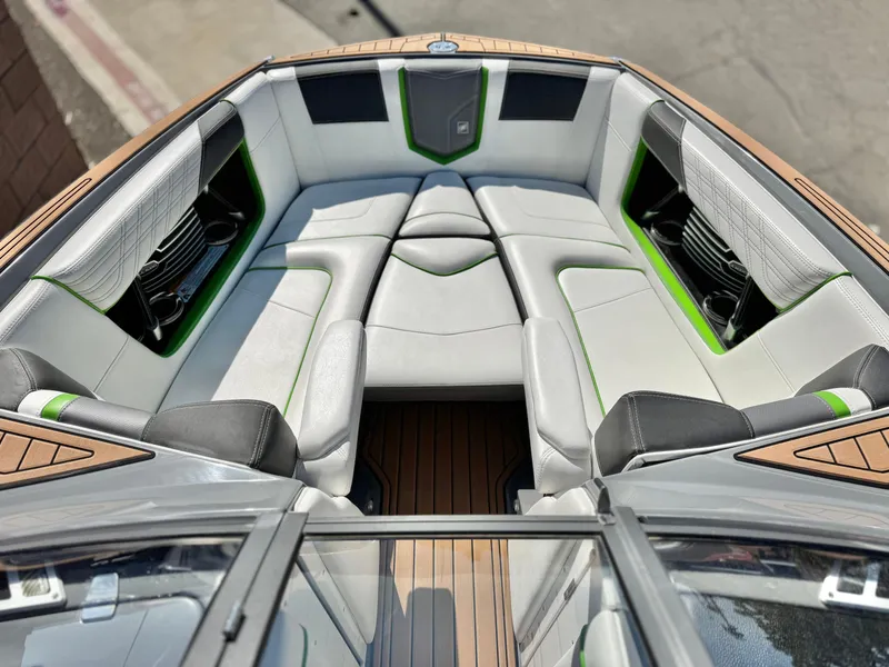 Slide: The Image of 2016 Nautique Super Air G23 boat interior with white and green seating, wood accents. - 15