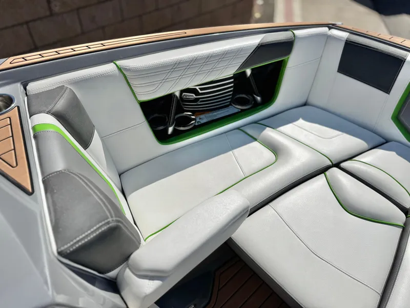Slide: The Image of 2016 Nautique Super Air G23 interior with gray and green seating, cup holders, and stylish design. - 16