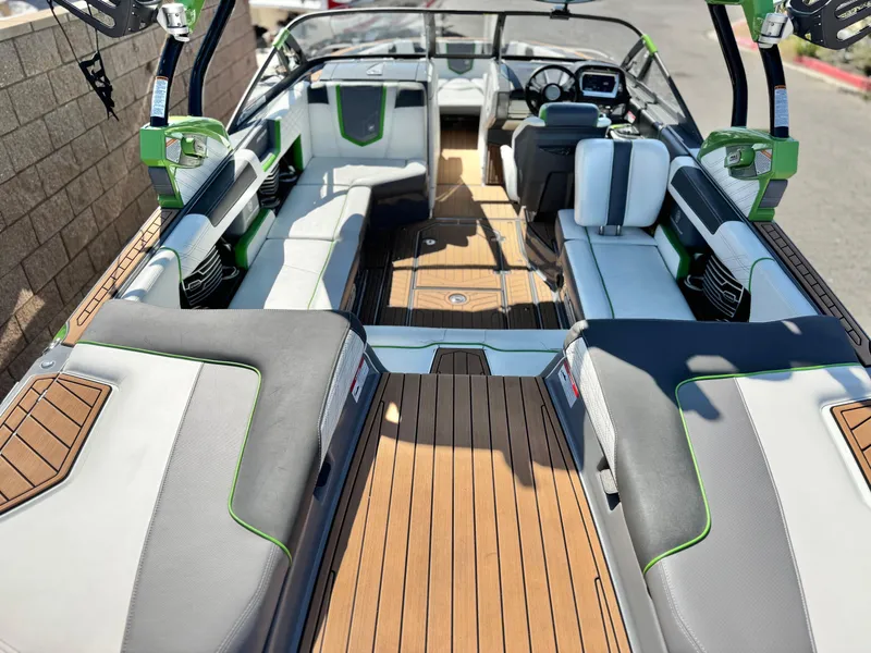 Slide: The Image of 2016 Nautique Super Air G23 interior with gray and green seating, wooden flooring. - 19