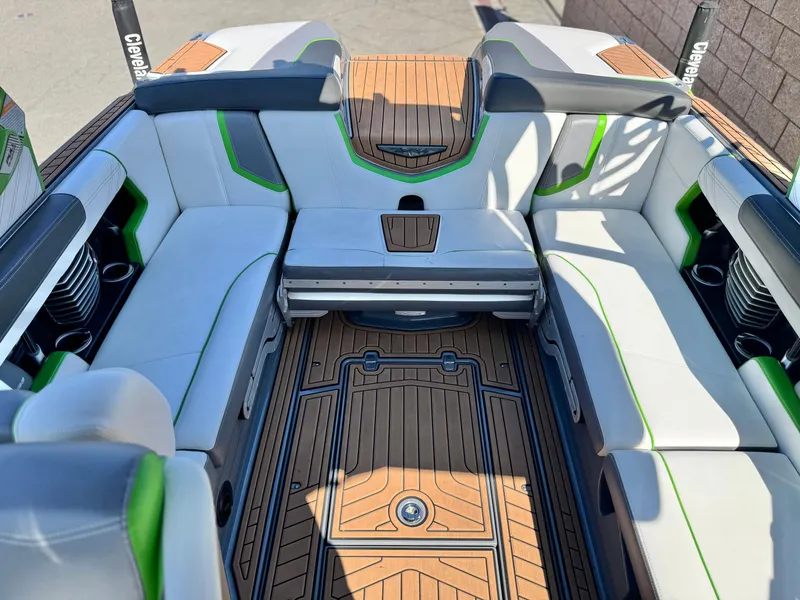 Slide: The Image of 2016 Nautique Super Air G23 interior with white and green seating, teak flooring, and cup holders. - 21