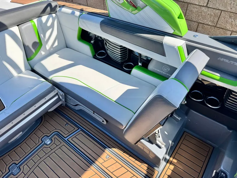 Slide: The Image of 2016 Nautique Super Air G23 interior with green accents and teak flooring. - 22
