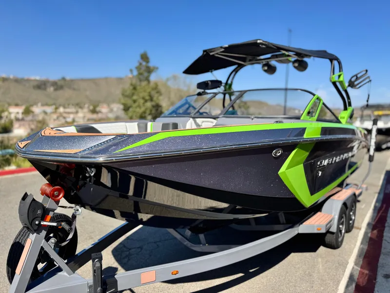 Slide: The Image of 2016 Nautique Super Air G23 boat on trailer, featuring sleek black and green design. - 3